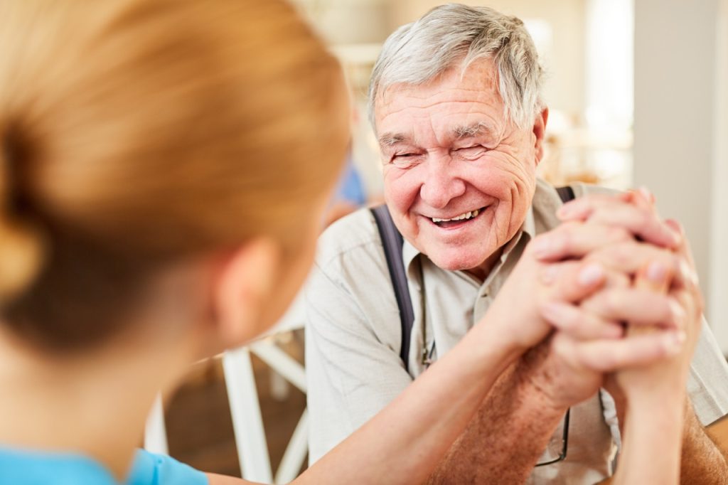 old man laughing with senior care provider